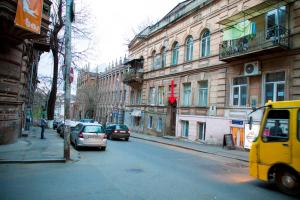 第比利斯Absolute Apartment的一条城市街道,汽车停在大楼的一侧