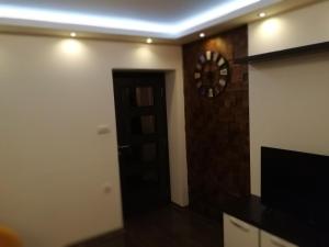 een kamer met een klok aan de muur en een deur bij Leon in Gornji Milanovac