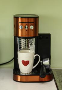 Una cafetera con una taza con un corazón. en Holiday Home 2 Palma en Durrës