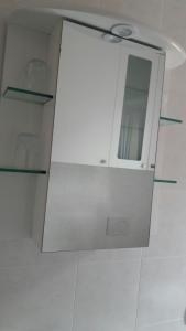 a bathroom with a white cabinet with a mirror at Gardens House in Varenna
