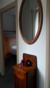 un espejo en una pared junto a una mesa con un espejo en Gardens House, en Varenna