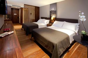 a hotel room with two beds and a television at Hotel Estelar Parque de la 93 in Bogotá