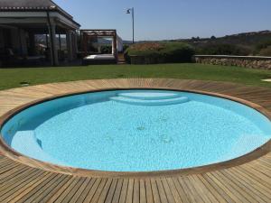 a large swimming pool on a wooden deck at La Sciumara Resort Palau in Palau