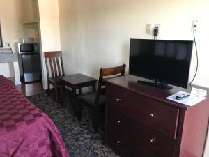 a hotel room with a flat screen tv on a dresser at Beachway Inn in Arroyo Grande