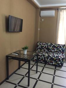 un soggiorno con divano, tavolo e TV di Амир a Gagra