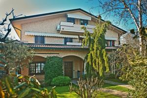 a brick house with a garden in front of it at B&BLaTosca in Marina di Massa