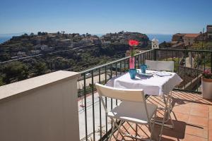 uma mesa e cadeiras numa varanda com vista em Dolce Vista Apartment Amalfi Coast em Scala