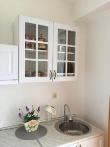 un bancone della cucina con lavandino e vaso di fiori di Aphrodite Gardens D208, studio apartment a Sunny Beach