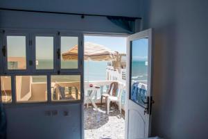 eine offene Tür zu einem Strand mit Meerblick in der Unterkunft Laverie du Soleil Surf House in Taghazout