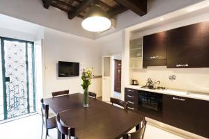 a kitchen with a table and chairs and a kitchen with a sink at Flatinrome Trastevere Complex in Rome