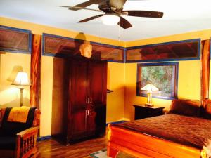a bedroom with a bed and a ceiling fan at Hawaiian Balinese Temple House in Pahoa