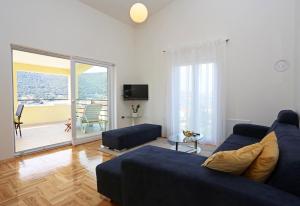 a living room with a blue couch and a sliding glass door at Villa Salvia Adriatica in Grebaštica