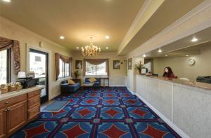 a woman standing in a lobby with a large carpet at Hotel Elan in San Jose