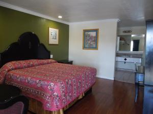 1 dormitorio con 1 cama con colcha roja en Castaway Motel en Orange