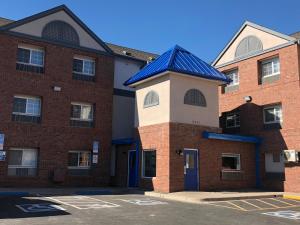 a brick building with a blue roof at InTown Suites Extended Stay Denver - Havana Street in Aurora