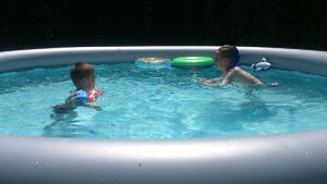 two young children playing in a swimming pool at Luxury house "Heart of Nature" Visoko in Visoko
