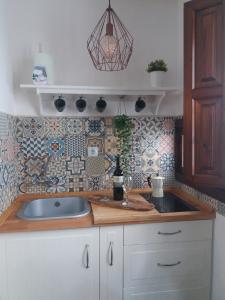 cocina con fregadero y pared de azulejos en Meraki Suites Albaycin, en Granada