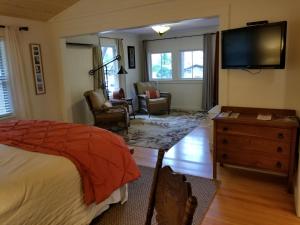 a bedroom with a bed and a flat screen tv at China Creek Cottages in Willow Creek