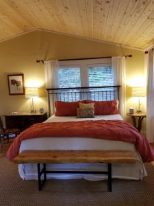 a bedroom with a large bed with a wooden headboard at China Creek Cottages in Willow Creek