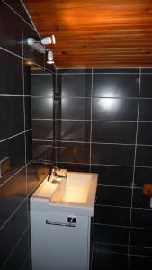 Łazienka z białą umywalką i czarnymi kafelkami w obiekcie Chez Babeth w Tuluzie