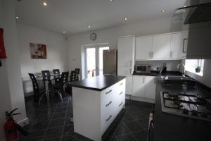 a kitchen with white cabinets and a black counter top at Holiday Home Hot Tub & Sauna in Bournemouth