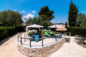 a patio with a table and chairs and umbrellas at Villa Ad Alta in Cannes La Bocca