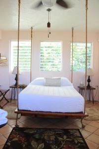 a bedroom with a large bed with a swing at El Yunque Rainforest Inn in Rio Grande