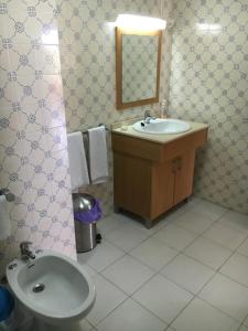 une salle de bain avec un lavabo, des toilettes et un miroir dans l'établissement Apartamento T1 Quinta Nova - Alvor, à Alvor 8 autres photos