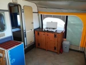 Habitación pequeña en una cabaña con ordenador portátil sobre una mesa en Caravan near the sea 2 en Ugljan