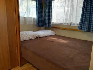 Bett in einem Zimmer mit Fenster in der Unterkunft Caravan near the sea 2 in Ugljan