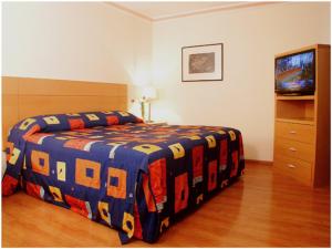 
a bedroom with a bed and a television at Hotel del Principado in Mexico City
