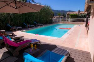 a swimming pool with lounge chairs and an umbrella at Villa Carpe Diem in La Roquette-sur-Siagne