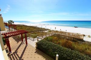 uma vista para uma praia com um banco vermelho e para o oceano em Majestic Beach Resort, Panama City Beach, Fl em Panama City Beach