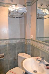 a bathroom with a toilet and a sink at Hostal Arévacos in Soria