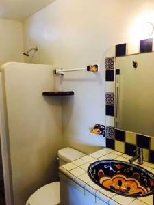 małą łazienkę z toaletą i umywalką w obiekcie Cielito Lindo Suites w mieście Puerto Escondido