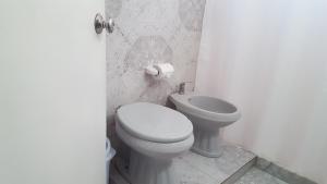 a white bathroom with a toilet and a sink at Bidieen Inn Uruguay in Carrasco +45 photos