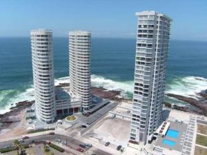 two tall buildings on the beach next to the ocean at Depto. Nautilus Piso 11 in Iquique