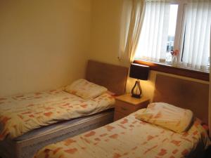 a bedroom with two beds and a lamp at Kilkerran Guest House in Ayr