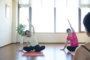 a man and a woman doing yoga in a room at Ibusuki Royal Hotel in Ibusuki