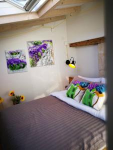 Schlafzimmer mit einem Bett mit Gemälden an der Wand in der Unterkunft cres art studio kuning apartment in Cres