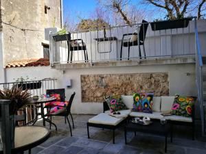 eine Terrasse mit einem Sofa, Stühlen und Tischen in der Unterkunft cres art studio kuning apartment in Cres