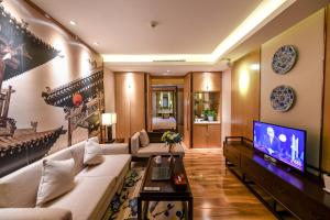 a living room with a couch and a tv at Water Hotel, Pingyao in Pingyao