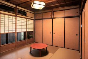 a room with a red stool and cabinets at Kiyomizuan 清水庵 車庫2台可 ビフォアアフターの匠 坂田基禎さん改築の京町家 in Kyoto