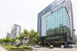 un grande edificio in vetro sul lato di una strada di Sun Hotel Kaohsiung a Kaohsiung