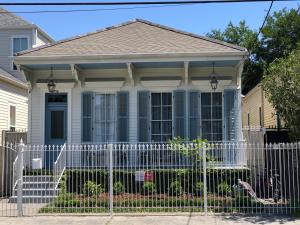 a white fence in front of a house at Creole Cottage Uptown in New Orleans