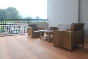 a room with a table and chairs and a balcony at Aurora Guest House in Wonosobo