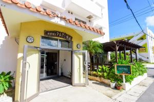 Zugang zu einem Restaurant mit einer Uhr auf einem Gebäude in der Unterkunft Hotel Patina Ishigakijima in Ishigaki-jima