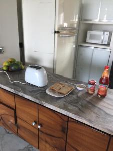 a kitchen counter with a toaster and bread on it at Pinaki Comfort Stay in Mumbai