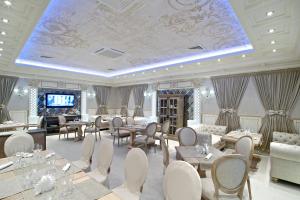 een grote kamer met tafels en stoelen en een televisie bij Grand Hotel Classic in Armavir