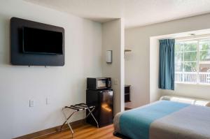 a hotel room with a bed and a tv on the wall at Motel 6-Mobile, AL in Tillmans Corner